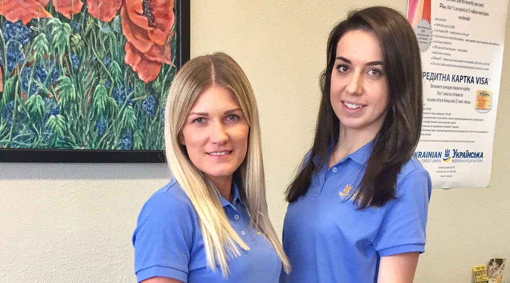 Two female staff smile during International Credit Union Day event