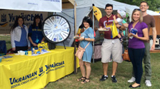 Festival attendees smile near UFCU booth