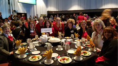 Group of female employees sit at table