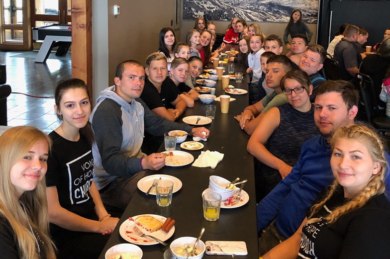 Large group of young adults sitting at table