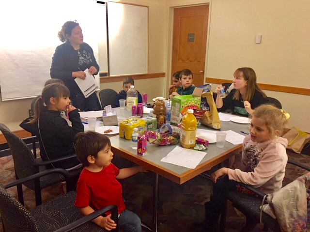 Children eating snacks and participating in financial seminar
