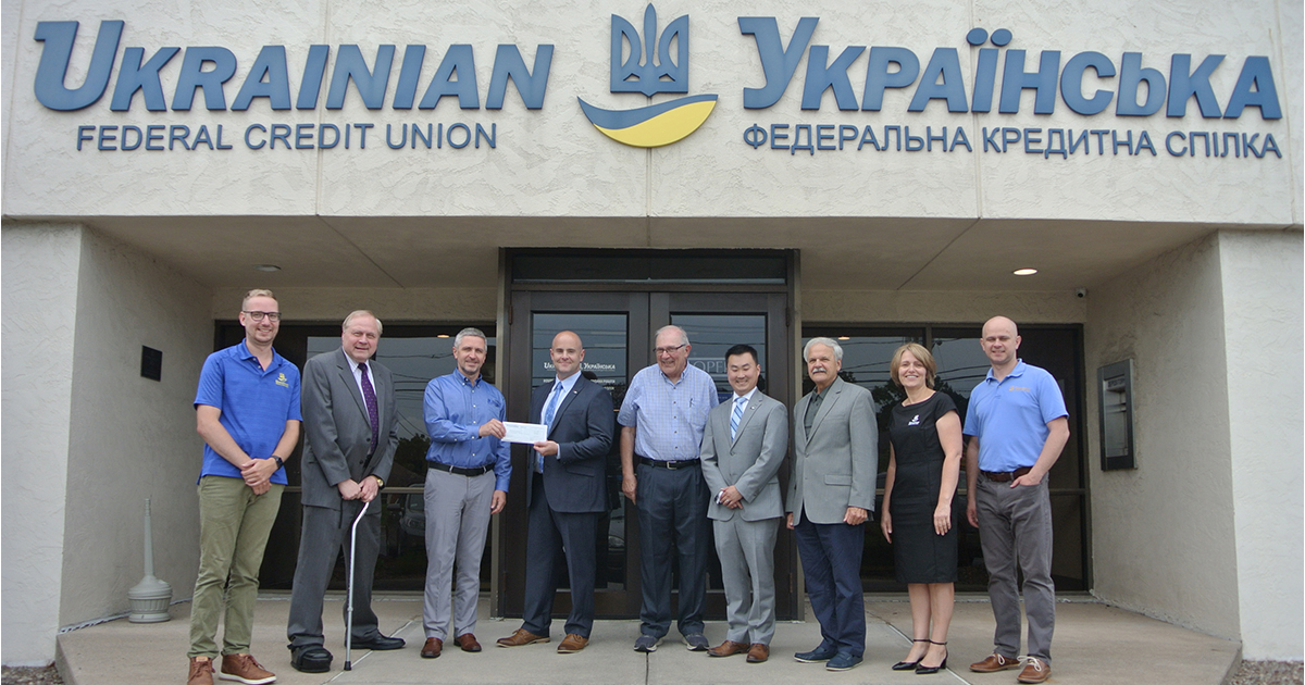 Group of adults standing check presentation