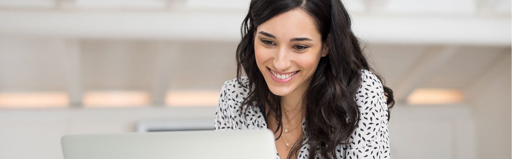 Female Smiling At Her Laptop