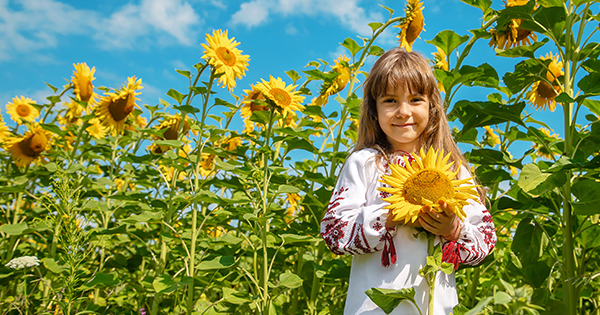 Child smiling holding sunflower