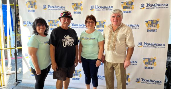 UFCU team with members near banner