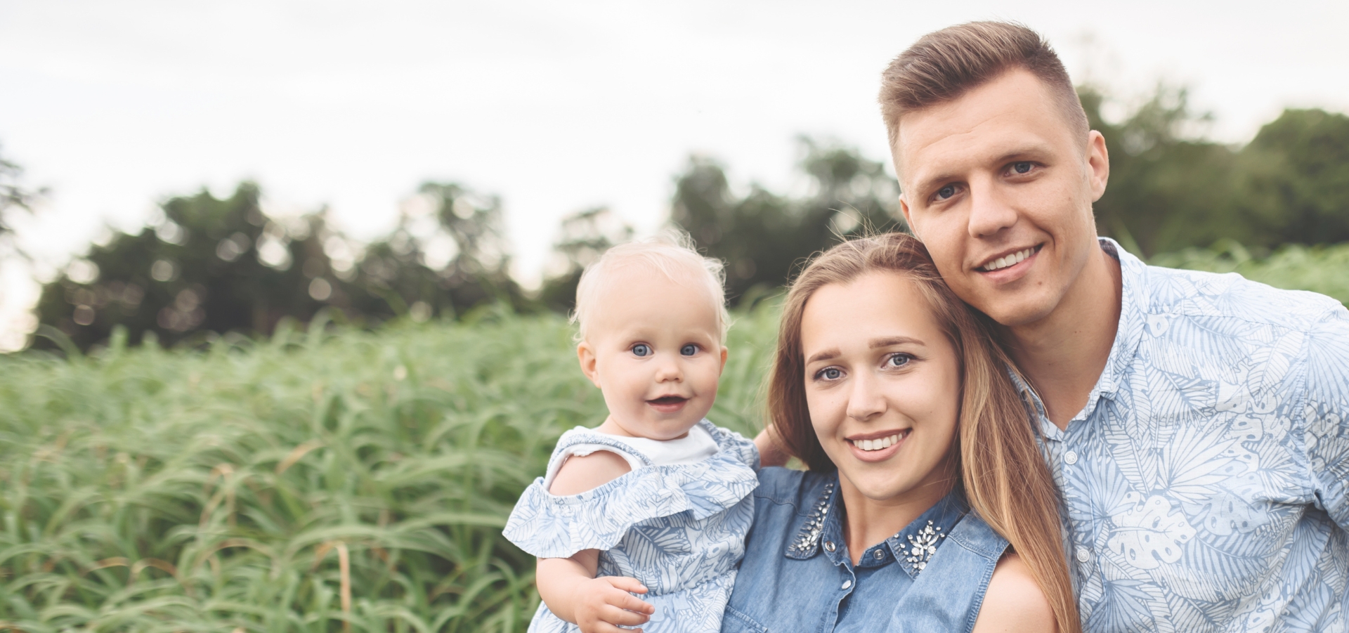 Family Of Three Happy In Grass Field